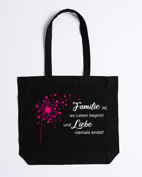 Stofftasche „Familie ist, wo Leben beginnt“ in Schwarz mit pinker Pusteblume und weißem Spruch