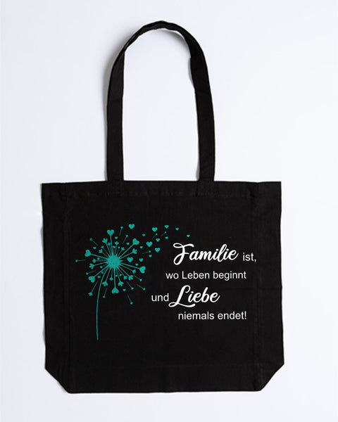 Stofftasche „Familie ist, wo Leben beginnt“ in Schwarz mit türkiser Pusteblume und weißem Spruch