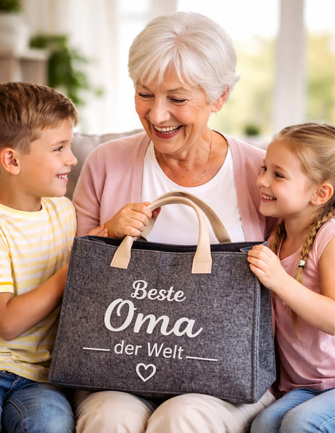 Kinder überreichen ihrer Oma eine Filztasche mit Aufdruck „Beste Oma der Welt“ als liebevolles Geschenk